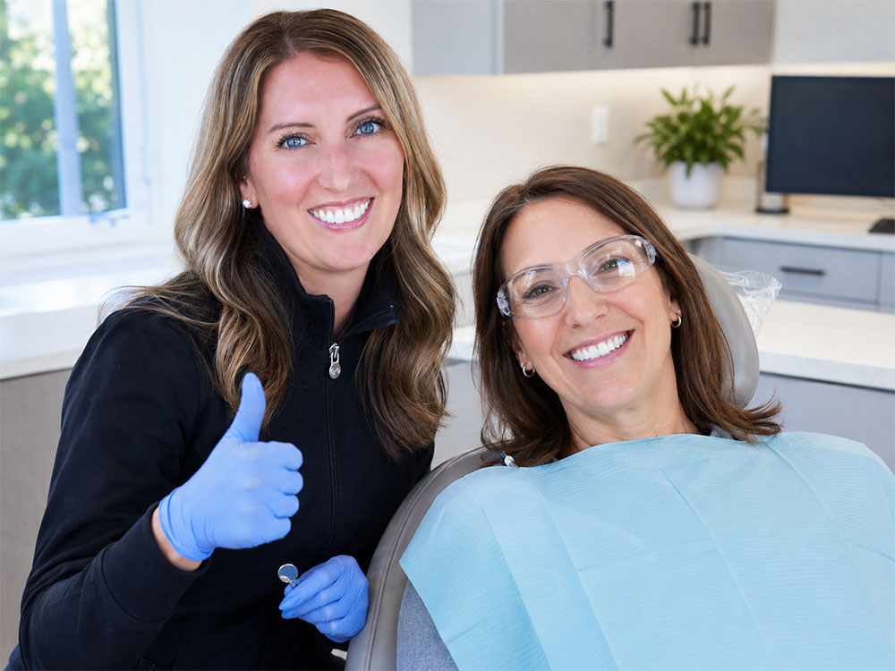 A Loomis Road Dental clinician giving a thumbs up beside a smiling patient in the chair